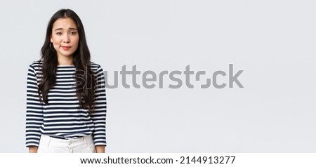 Lifestyle, people emotions and casual concept. Shy and modest cute clueless girl, smirk and looking camera uncertain, having doubts or hesitations, standing white background
