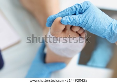 Doctor conducts medical examination of foot with patch. Pain attacks concept Royalty-Free Stock Photo #2144920425