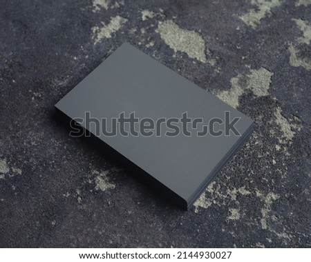 Stack of grey business cards on concrete background. Branding mock up.