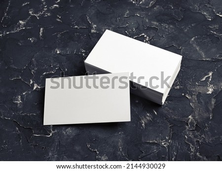 Photo of blank business cards on black plaster background. Template for ID. Mock-up for branding identity.