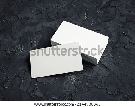 Photo of blank business cards on black plaster background. Template for your design.