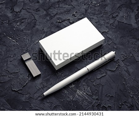 Blank business card, usb flash drive and pen on black plaster background. Mockup for branding identity. Template for graphic designers portfolios.