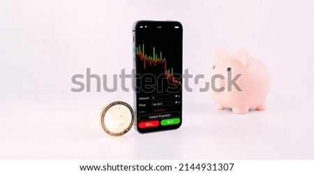 Crypto currency exchange. Pink pig bank, gold crypto currency BTC bitcoin on white background. Bitcoin trading mobile phone app. Save money investment and business finance