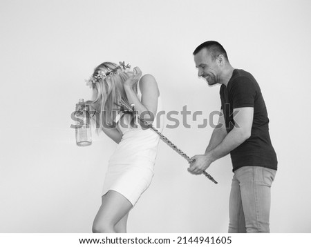 attractive boy whipping young girl with homemade easter whip on easter monday. tradition in slovakia and Czechrepublic. man and woman having fun. lady

holding bottle of alcohol and chocolate bunny Royalty-Free Stock Photo #2144941605
