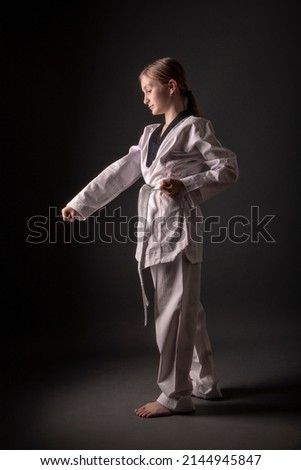 one caucasian girl practicing Taekwondo in studio 