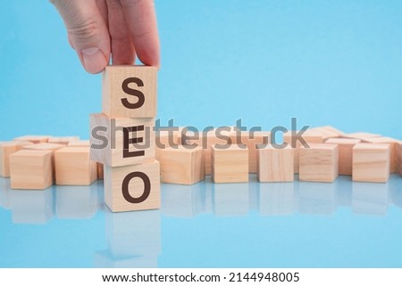hand holding wood cube block with SEO text. financial, management, economic, business concept