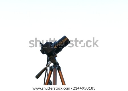 Close up of a black camera. Attached at one tripod. White background. Close up and isolated.