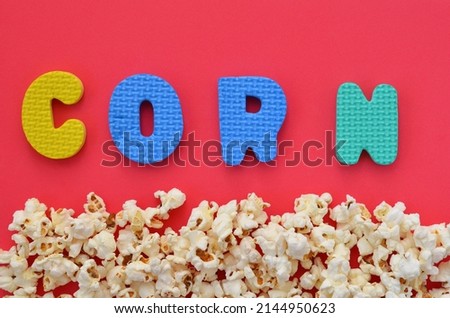 sprinkled popcorn on a red background and the word corn