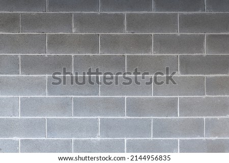 Cement concrete grey brick wall backdrop with symmetrical lines, urban background, cinderblock texture Royalty-Free Stock Photo #2144956835