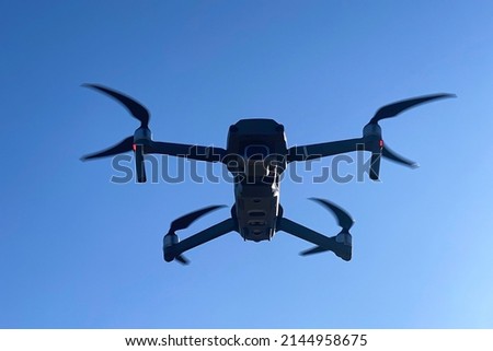 Quadcopter in flight against the blue sky, takes pictures and shoots video from the quadcopter