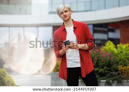 Portrait of a young hipster with a phone in his hands.