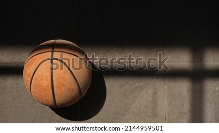 Top view orange ball for basketball lying on floor outside house in morning sun. Copy space