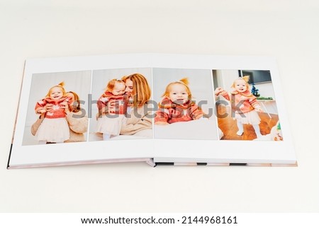a Photobook of family at home on a white background. Photobook is gift. professional photographer and designer. printing of photos and journals in photo laboratory. mother and daughter