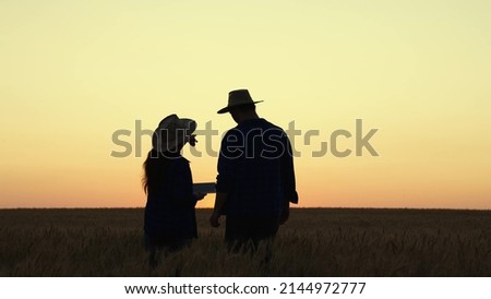Business people, companions evaluate wheat field, grain harvest. Farmer, partners in wheat field. Grow food. Farmer, man, woman work together in field in summer, rich harvest of wheat. Agriculture Royalty-Free Stock Photo #2144972777