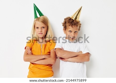 picture of positive boy and girl in multicolored caps birthday holiday emotion light background