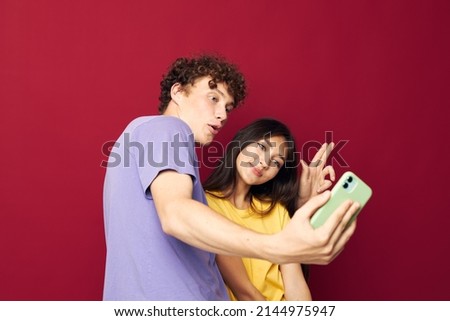 teenagers in colorful T-shirts with bags Shopping red background unaltered