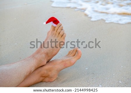 santa claus hat is worn on the toe on the beach