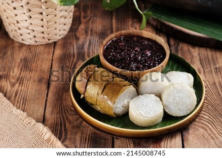 Lemang Tapai, is a typical Indonesia Padang food, made from white sticky rice, coconut milk and salt, then grilled in a bamboo stick and served with tapai, fermented black sticky rice. Selective focus Royalty-Free Stock Photo #2145008745