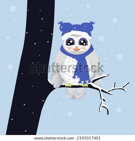 Cute snowy owl sits on a tree branch in winter