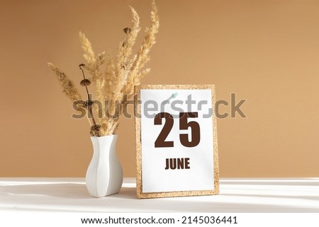 june 25. 25th day of month, calendar date.White vase with dried flowers on desktop in rays of sunlight on white-beige background. Concept of day of year, time planner, summer month.