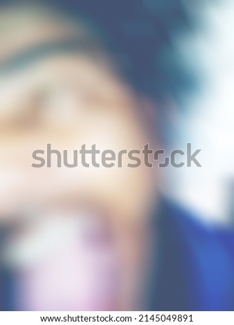 An Indian or asian man showing his funny facial expression to the camera. Blurred or defocused image.