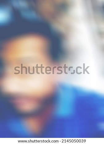 An Indian or asian man showing his funny facial expression to the camera. Blurred or defocused image.