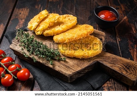 Hash brown potato, Potato Patties on a wooden board with ketchup. Wooden background. Top view. Royalty-Free Stock Photo #2145051561