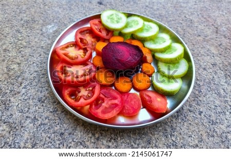 Stock photo of classic healthy and colorful salad plate with tomato, beetroot, cucumber and carrot, kept on table under nature light. Picture captured at Bangalore, Karnataka, India.