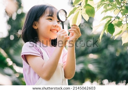 Asian little girl is using magnifying glass to play in the park
 Royalty-Free Stock Photo #2145062603