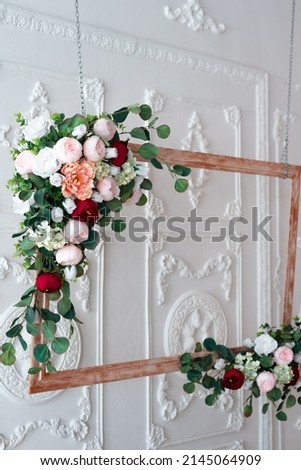 Wooden frame decorated with artificial flowers. Wedding composition. Flowers on a stand.