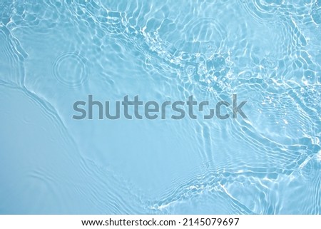 Transparent blue clear water surface texture with ripples, splashes and bubbles. Abstract nature background Water waves in sunlight. Cosmetic moisturizer micellar toner emulsion. Top view, copy space Royalty-Free Stock Photo #2145079697
