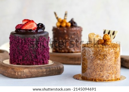 Types of cakes. Varieties of small cakes on a white background. Bakery products. Close-up. Royalty-Free Stock Photo #2145094691