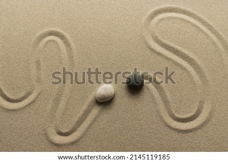 Zen meditation sand and two pebbles curved traces symbol image encounter Royalty-Free Stock Photo #2145119185