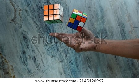 Male hands playing a rubik's cube                               Royalty-Free Stock Photo #2145120967