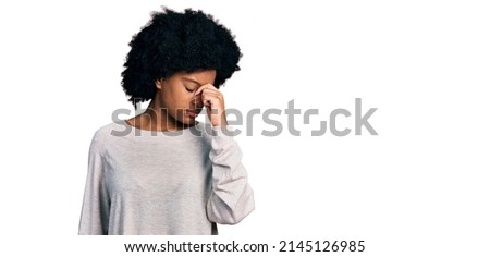 Young african american woman wearing casual clothes tired rubbing nose and eyes feeling fatigue and headache. stress and frustration concept. 