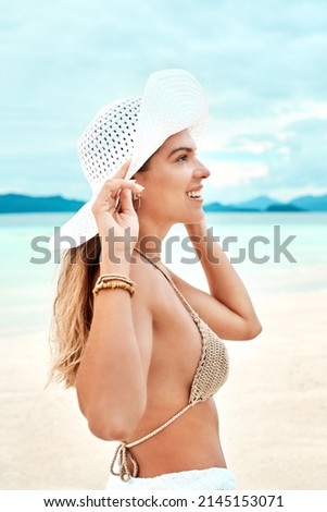 Everything is fine when theres sunshine. Shot of a beautiful young woman spending time at the beach on a sunny day.