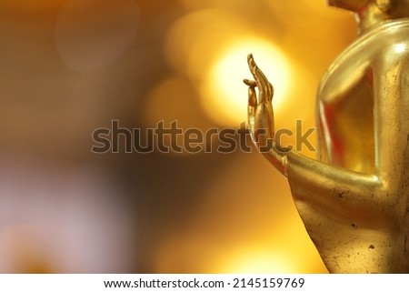 Buddha's hand with OK look and golden yellow background.