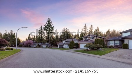 Fraser Heights, Surrey, Greater Vancouver, BC, Canada. Street view in the Residential Neighborhood during a colorful spring season. Colorful Sunset Sky Art Render. Royalty-Free Stock Photo #2145169753