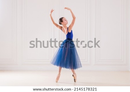 professional student ballerina doing pointe shoes in beautiful white room