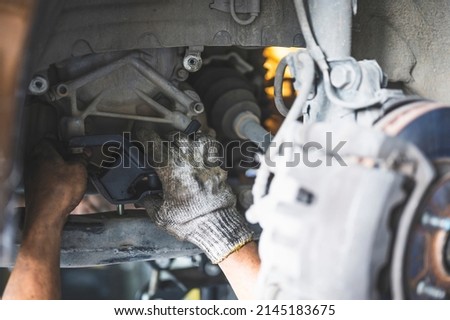 Car mechanic replacing transmission mounts. Royalty-Free Stock Photo #2145183675