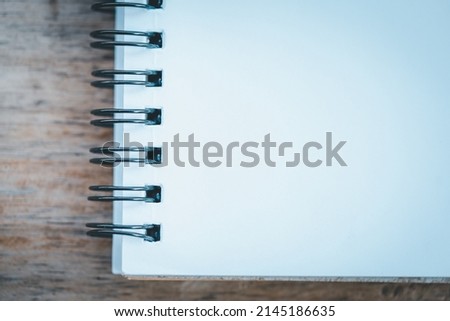 Blank one face white paper notebook pace on wood background
