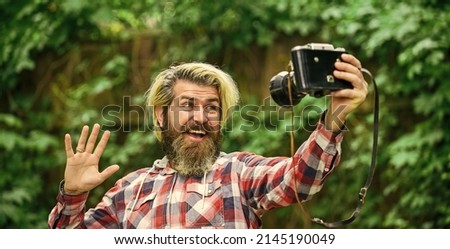 photography in modern life. travel tips. professional photographer use vintage camera. selfie time. bearded man hipster take photo. photo shooting outdoor. brutal man traveler with retro camera