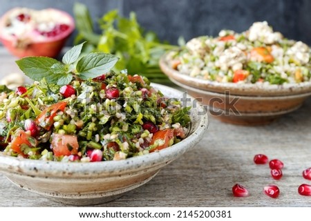 Tabbouleh salad with parsley, mint, bulgur and pomegranate. Fresh salad with herbs. Royalty-Free Stock Photo #2145200381