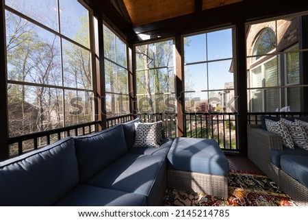 Contemporary screened porch in springtime, full of blooms trees in the background. New home addition concept.