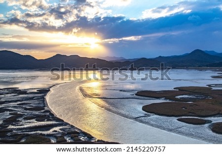 Sunset and aerial view of curved sea waterway and mud flat at low tide against sunshine at Suncheon Bay near Suncheon-si, South Korea 
 Royalty-Free Stock Photo #2145220757