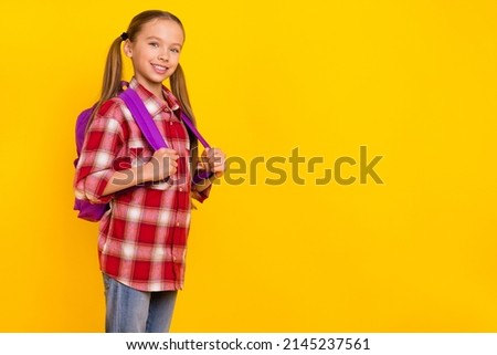 Photo of pretty adorable schoolkid dressed plaid shirt walking arms shoolbag empty space isolated yellow color background
