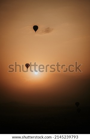 Cinematic Moody Hot Air Balloons during sunset sunrise over the desert mountains 