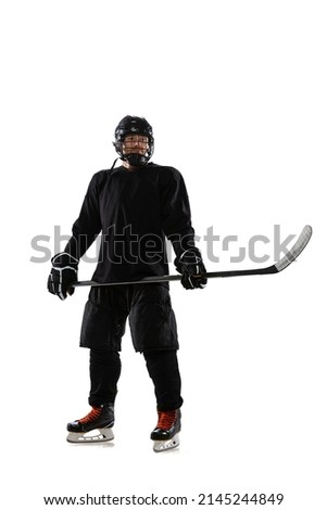Full-length portrait of professional hockey player in special protective unifrom posing with stick isolated over white studio background. Concept of sport, action, movement, health. Copy space for ad