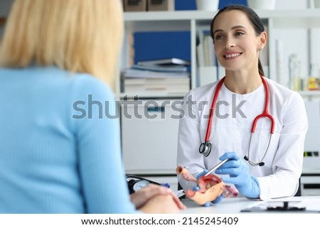 Gynecologist holds model of female reproductive system of uterus and consults patient. Gynecological diseases in women concept