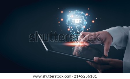 Artificial intelligence (AI) concept. Hand touch tablet brain with shining wireframe, Neural networks in light bulb of business networking technology innovation. Royalty-Free Stock Photo #2145256181